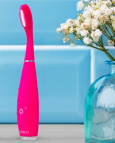 FOREO ISSA sonic silicone toothbrush next to flowers
